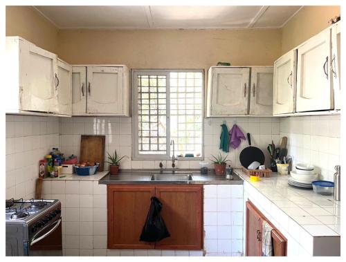 a kitchen with white cabinets and a sink at Homestay in Wilkinson road in Freetown