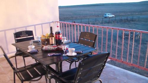 a table with bottles of alcohol and chairs on a balcony at guesthouse gareji in Udabno