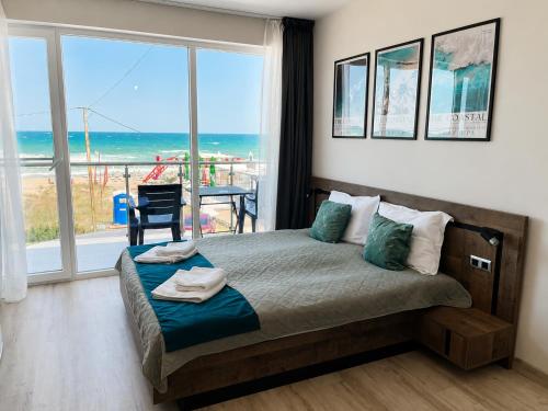a bedroom with a bed with a view of the ocean at Paradise View Rooms in Shkorpilovtsi