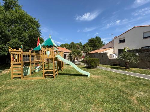 a playground with a slide in a yard at Au Petit Bignon in Les Épesses