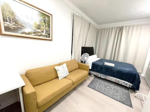 a living room with a couch and a bed at Queen Boutique Rooms in Toronto