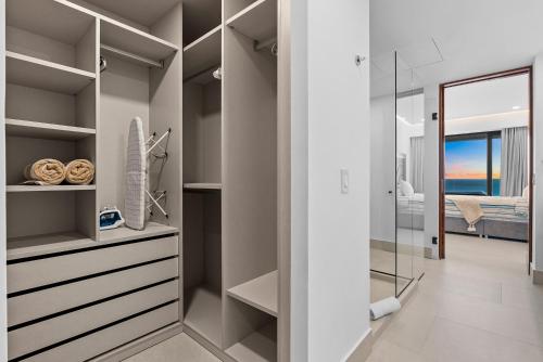 a walk in closet with a glass door leading to a bedroom at PANAREA - Luxury Beachfront Condos in Bucerias in Bucerías