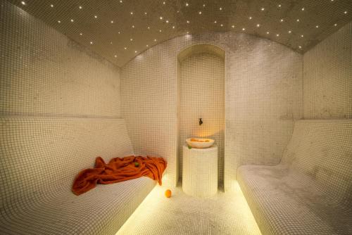 a bathroom with a tub and a table in it at Promenade Hotel Liepaja in Liepāja