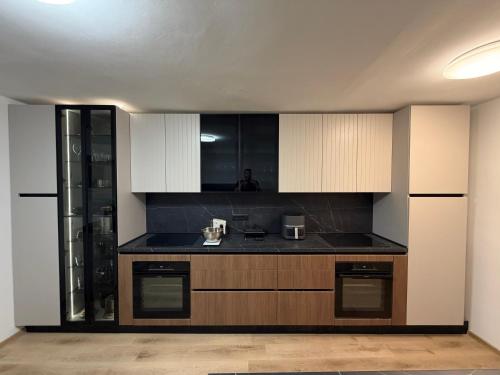 a kitchen with black counter tops and white cabinets at Soti Apartments in Kupari