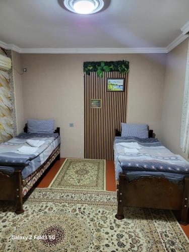 a room with two beds and a door with a rug at Shabran Pearl Oasis - Family Garden House - Ailəvi Bağ Evi in Surra