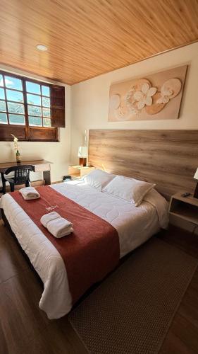 a bedroom with a large bed with two towels on it at Hotel Boutique Villa Mercedes in Sopó