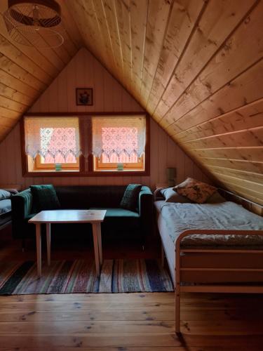 a room with a bed and a table in a attic at Siedlisko Leśny Jaśmin in Łuka
