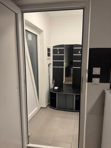 a bathroom with a sliding glass door with a mirror at Studio Maša in Zaječar
