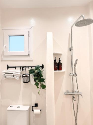 a white bathroom with a shower and a toilet at Central Parikia stay-Helios in Parikia