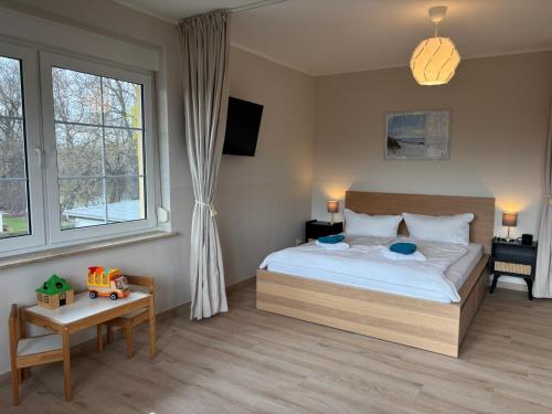 a bedroom with a bed and a table and windows at Seeblick Apartments Mühlau in Mühlau