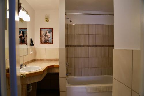 a bathroom with a sink and a tub and a toilet at Motel Bel-Eau in Montebello