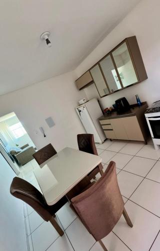 a kitchen with a table and chairs in a room at 1- Apartamento aconchegante 1200m do Centro in Serra Talhada