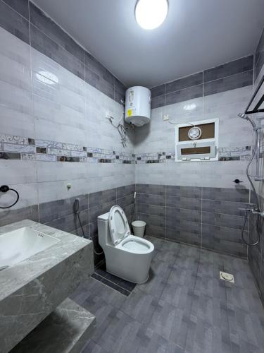 a bathroom with a toilet and a sink and a tub at جوهرة الخوض in Al Khawḑ
