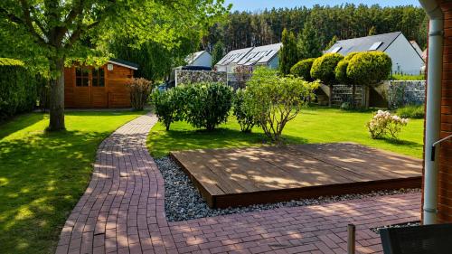 a garden with a wooden walkway in a yard at Ostseeferienhaus Usedom Lütow am Achterwasser Hundefreundlich Naturlage Familie Christian Ziethen in Lütow
