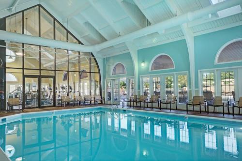 a swimming pool in a building with chairs and windows at Kingsgate Resort 1BR Apartment in Williamsburg