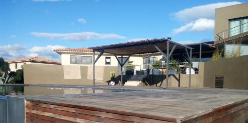 a house with a deck and a swimming pool at Chambres d'Hôtes Bianca Casa in Porto-Vecchio