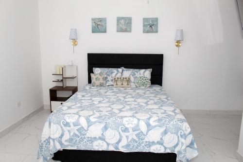 a bedroom with a bed with a blue and white comforter at Apartment in Ancon in Ancón