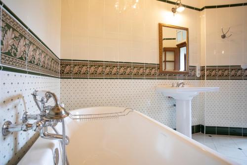 a bathroom with a tub and a sink at Le Logis d'Equilly in Équilly