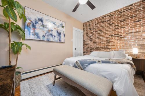 a bedroom with a brick wall and a bed at Spacious & Stylish 2BR Apartment Near Manhattan in Jersey City