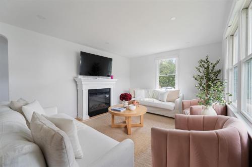 a living room with a white couch and a fireplace at Renovated Cape Near Beach with Fire Pit in Fairfield