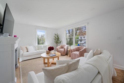 a white living room with white couches and a table at Renovated Cape Near Beach with Fire Pit in Fairfield