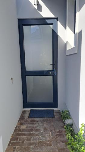 eine Tür mit einem Glasfenster an der Seite eines Gebäudes in der Unterkunft Flip-Flops studio in Hermanus