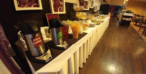 a long counter with a row of coffee makers and drinks at BNC Hotel - Restaurant - Bowling in Bratislava