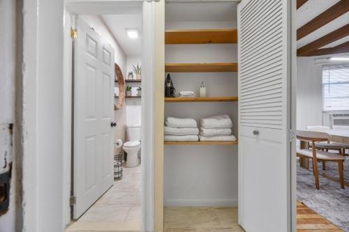 a hallway with a door leading to a room with towels at Spacious & Stylish 2BR Apartment Near Manhattan in Jersey City