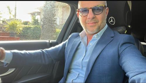a man in a suit sitting in a car at Modica Blu Oceano in Modica