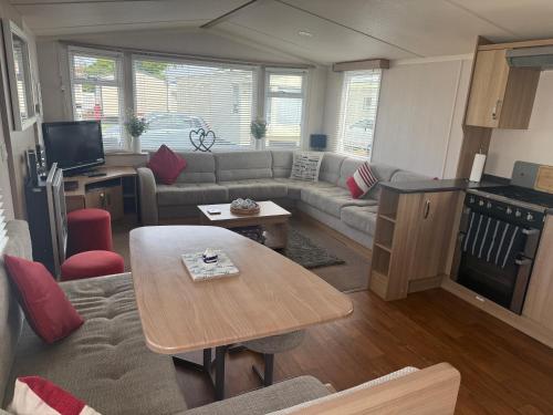 a living room with a couch and a table at CJ Coastal Getaway #2 in Rhyl