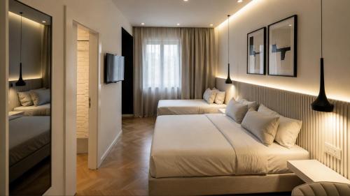 a hotel room with two beds and a tv at The Central Stay Cagliari in Cagliari