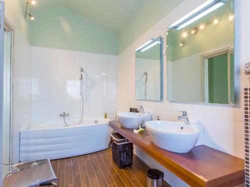 Un baño con dos lavabos y una bañera. en Villa Splendida, en Poreč