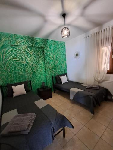 a room with two beds and a green wall at Endless blue apartment kassandra in Nea Fokea