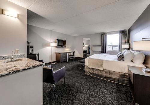 a hotel room with a bed and a sink at Heritage Inn Hotel & Convention Centre - High River in High River