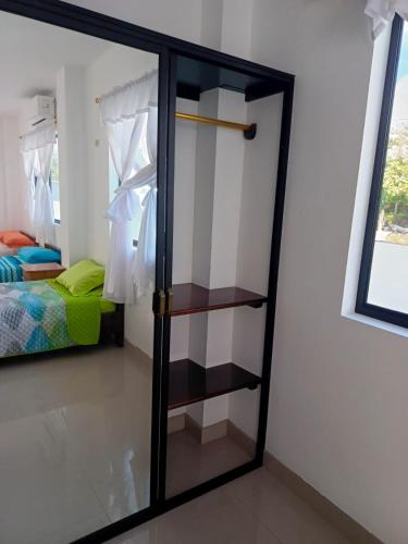 a glass door in a room with a bedroom at Iguana Marina House in Puerto Villamil