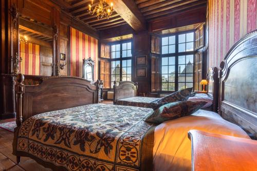a bedroom with two beds in a room with windows at Le Logis d'Equilly in Équilly