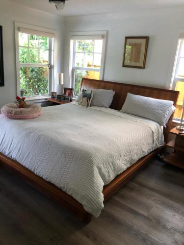 a large bed in a bedroom with two windows at Northwood Revival in West Palm Beach