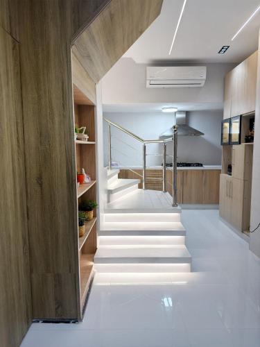 a staircase in a house with white floors and wooden walls at Natalie Aqua villa heated pool 3BD DeadSea in Al Kafrayn
