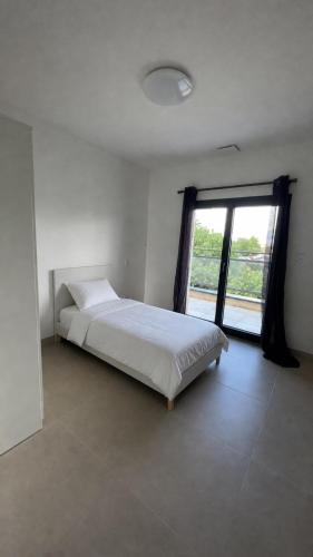 a bedroom with a bed and a large window at Maison 3 chambres in Avignon