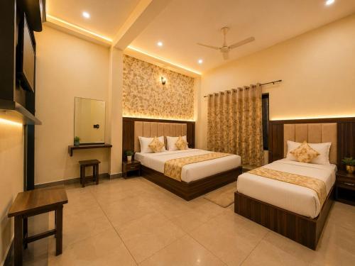 a hotel room with two beds and a television at Hotel Crystal Blues in Mathura