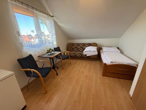 a room with two beds and a table and a window at Villa Alexandria in Darłówko