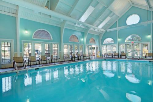 a swimming pool with chairs in a building at Kingsgate Resort 2BR Apartment in Williamsburg
