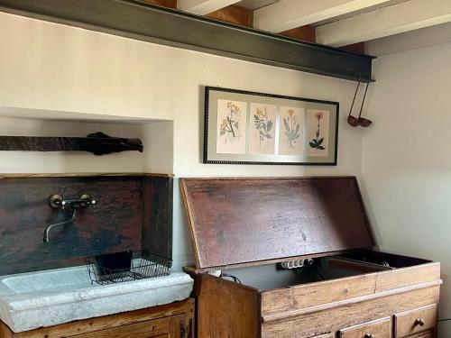 a kitchen with a sink and a wooden cabinet at Dimora 45, Contemporary Apartments in a Historic Building, Valdichiana, Tuscany in Sinalunga