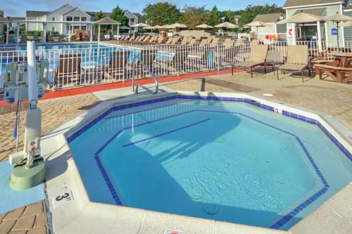 a swimming pool at a resort with chairs and tables at Kingsgate Resort 3BR Apartment in Williamsburg
