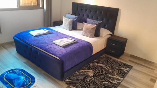 a bedroom with a large bed with purple sheets and pillows at Welcome Home in Beni Mellal