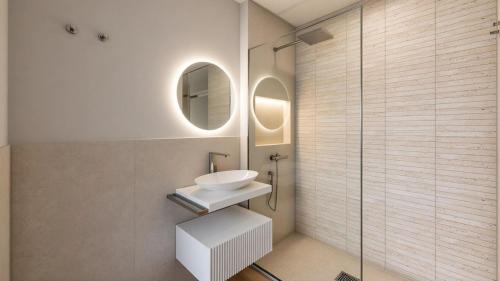 a bathroom with a sink and a glass shower at The Central Stay Cagliari in Cagliari