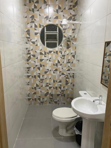 a bathroom with a toilet and a sink at Maresia in Cacoal