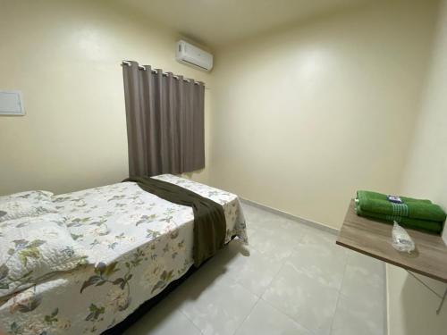 a bedroom with a bed and a wooden table at Maresia in Cacoal