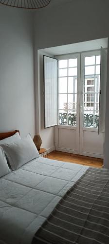 a bedroom with a bed and a large window at Jomafreitas in Ponta Delgada