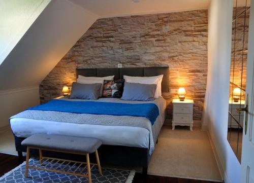 a bedroom with a large bed with a stone wall at Ferienhaus Rosengarten Mürlenbach in Mürlenbach